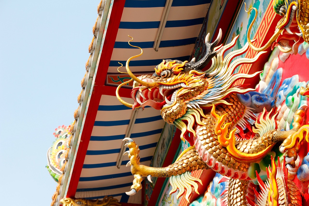 A vibrant dragon statue adorns the side of a building, showcasing intricate details and bright colors.jpg