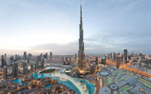 A stunning view of the Dubai skyline illuminated by the warm hues of sunset, showcasing iconic skyscrapers against the sky.jpg