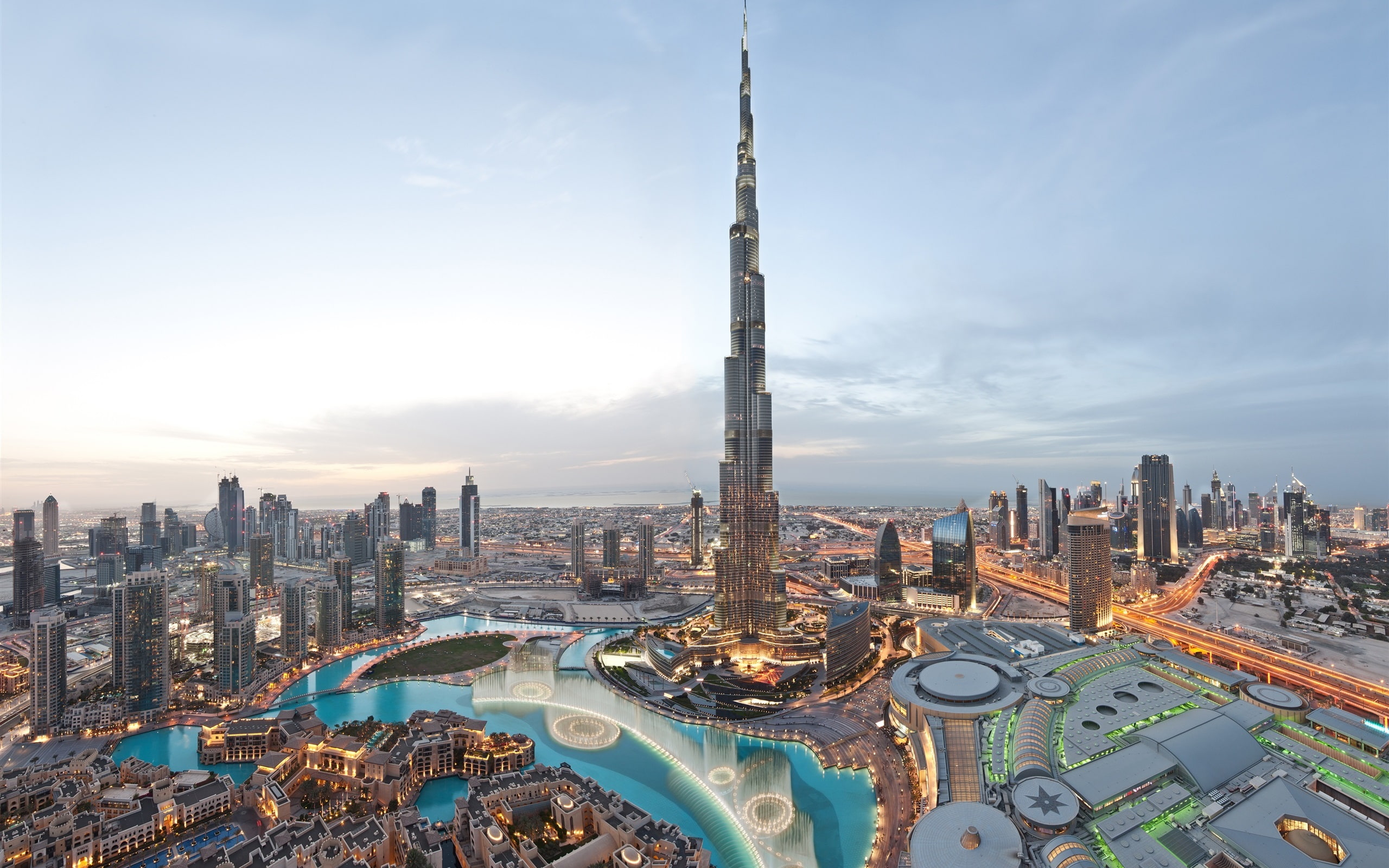 A stunning view of the Dubai skyline illuminated by the warm hues of sunset, showcasing iconic skyscrapers against the sky.jpg