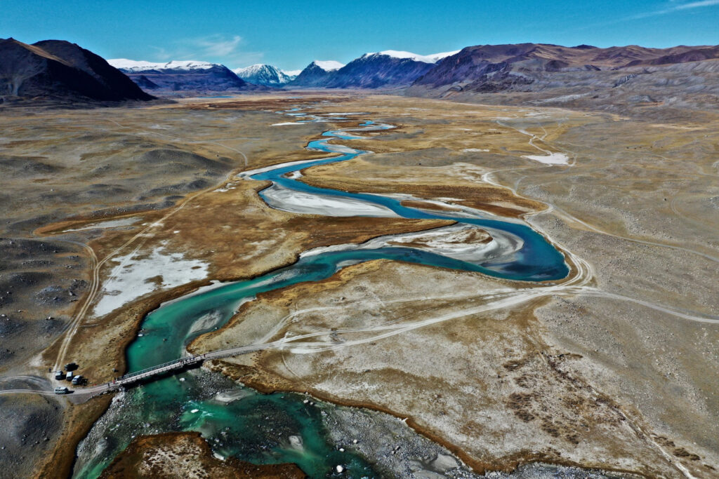 aerial-view-of-a-winding-river-flowing-gracefully-through-a-lush- green-valley,- surrounded-by-hills- and-trees.jpg