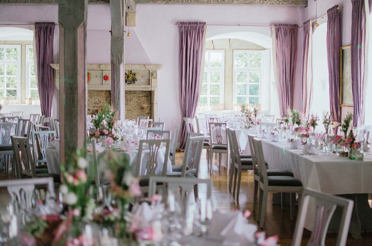 A large room adorned with purple walls, set up for a wedding reception at the Exotic Wedding Planning Conference 2025.jpg