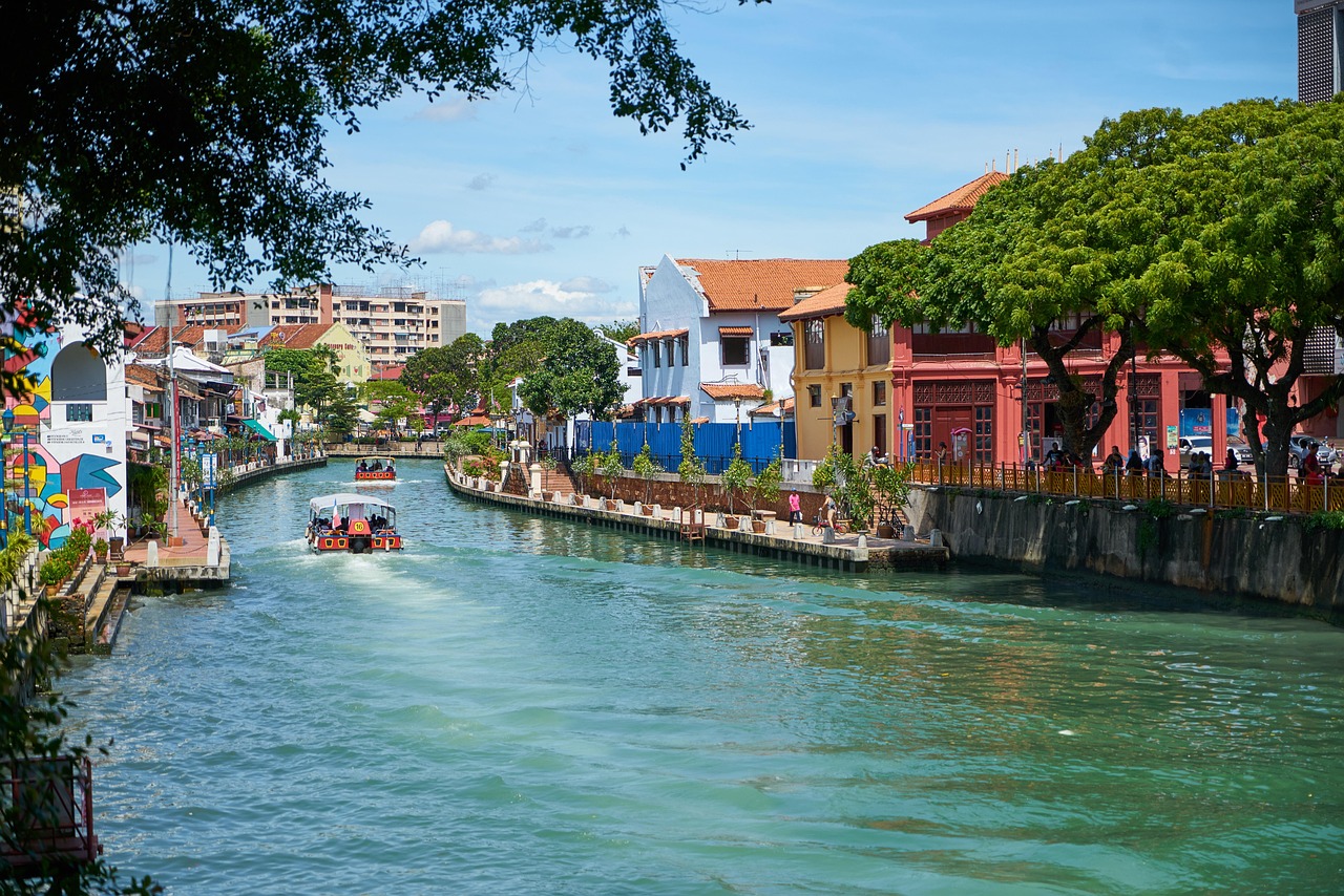 A boat glides down a river surrounded by city buildings, showcasing urban life and waterway transportation.jpeg