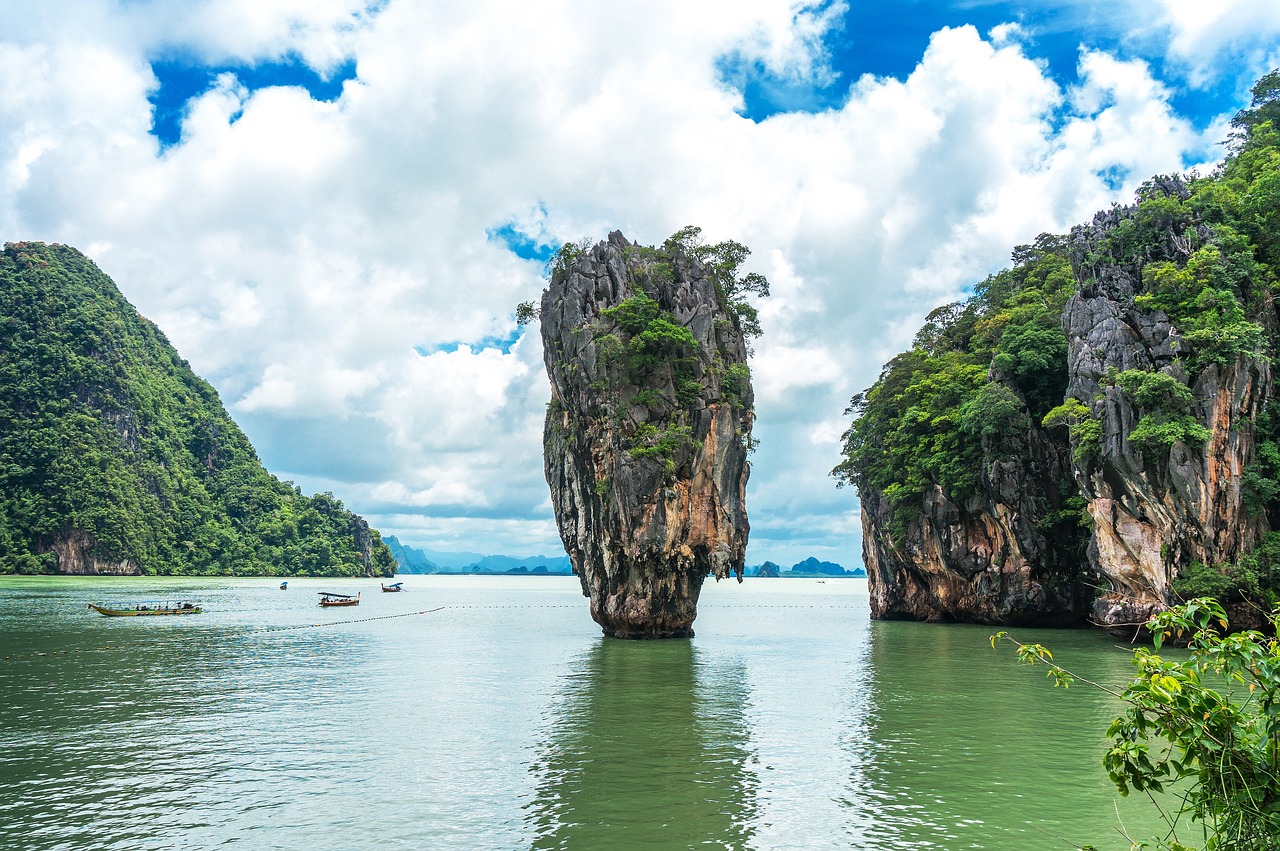 Tall rock formations rise dramatically from the water, showcasing Thailand's natural beauty in a scenic tour package from Dubai.jpg
